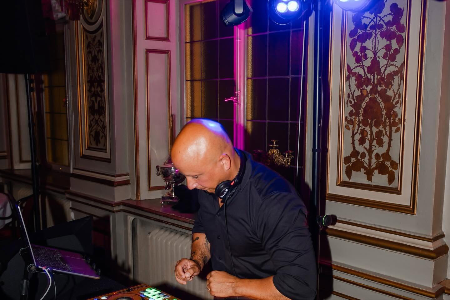 Dennis vid DJ-båset under ljusriggen i en klassisk festvåning
